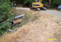 Before: Stream crossing  displays 3 old drainage structures - a small culvert, on a larger culvert, on buried "Humboldt" logs.