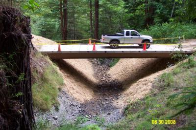 After: The bridge has been installed and the bare sideslopes mulched with straw to control erosion