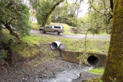 After: An emergency overflow culvert was installed to prevent overtopping when the primary culvert capacity is exceeded 