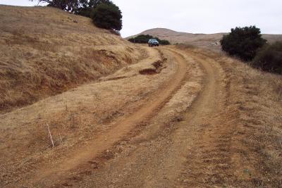 Before: Note the deep wheel ruts and the gully erosion leading to the inboard ditch of this insloped road reach.