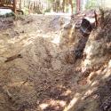 View of the old culvert outlet from the stream bank below. Trees and brush have been cleared to prepare for upgrading.